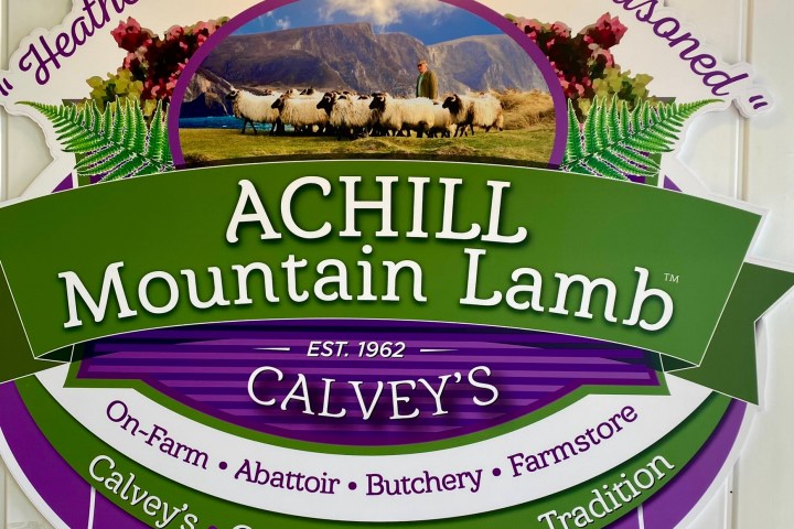 Sign for Calvey's Achill Mountain Lamb with scenic sheep photo and contact details.