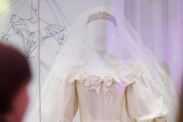 White wedding dress with veil and tiara on display mannequin.