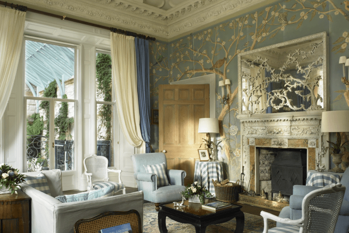 Elegant living room with blue walls, ornate fireplace, and classic furniture.