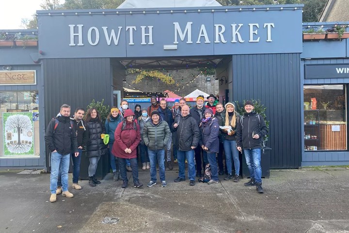 Group of people posing outside Howth Market entrance.