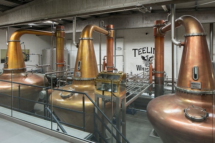 Copper distillation stills inside a modern whiskey distillery.