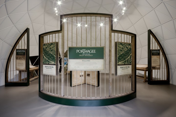 Whiskey display with Portmagee signage and wooden frames in a geometric dome room.