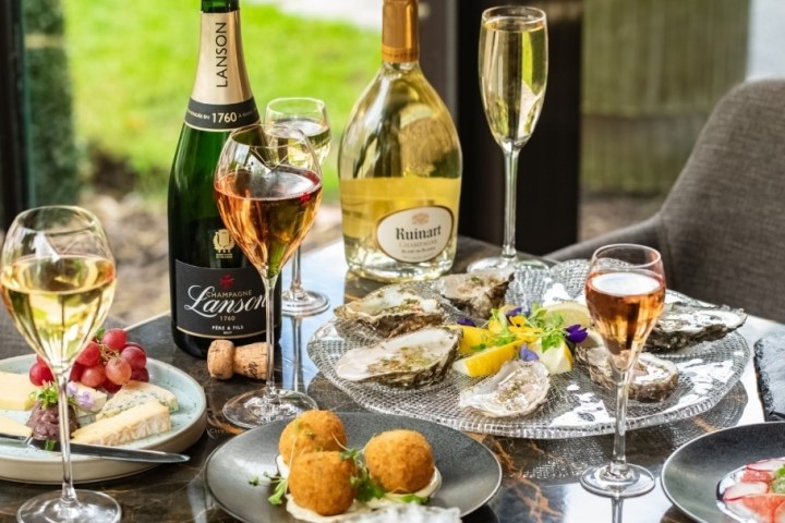 Table with oysters, cheese, champagne, and various appetizers.