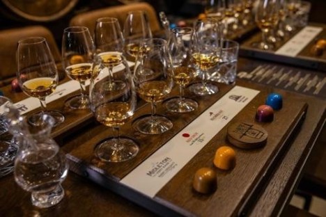 Glasses of whiskey and chocolates arranged on tasting boards.