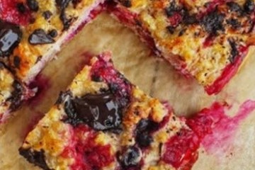 Close-up of a baked fruit and chocolate dessert on parchment paper.